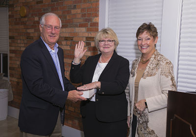 Debbie Wood (center) takes the oath of office, administered by Caswell Beach Mayor Deborah Ahlers. Holding the Bible is Wood’s husband, Kent.Debbie Wood (center) takes the oath of office, administered by Caswell Beach Mayor Deborah Ahlers. Holding the Bible is Wood's husband, Kent.