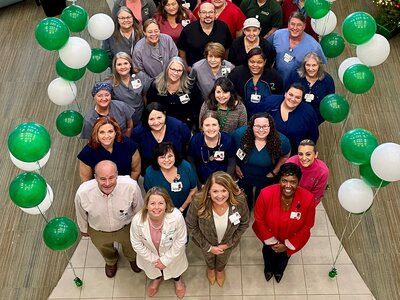 Members of the Dosher staff stand behind the hospital Senior Team, who are L-R, Chief Financial Officer Ed Tusa, Chief Medical Officer Mesha Chadwick, MD, Chief Officer Nursing Officer Jill Ward, and President and CEO Lynda Stanley, at a celebration held last year for their 5-star patient survey rating. Dosher Celebrates National Hospital Week